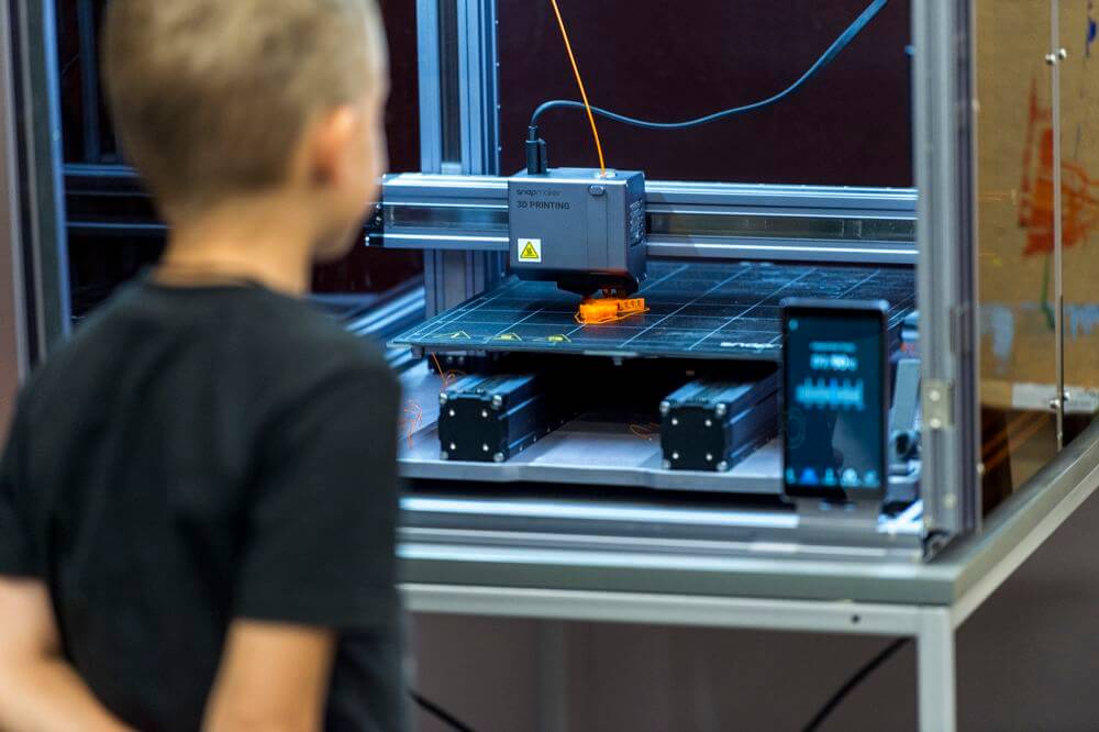 Дитина спостерігає, як друкується 3D модель